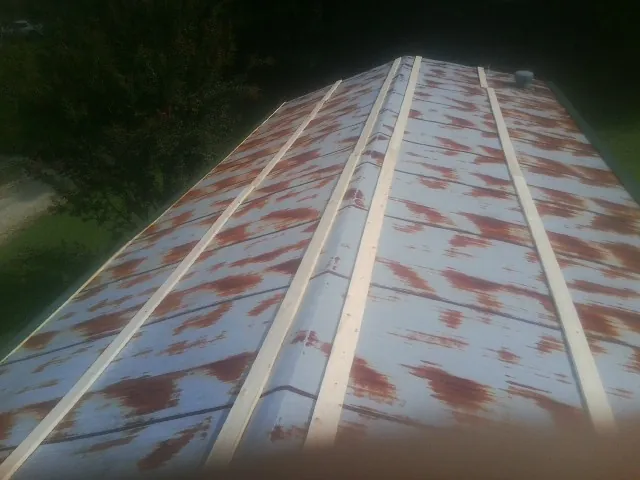 Rusted metal roof panels with new wood purlins before replacement — Storm Damage Roof Repair in Edwards by Roofing Brothers